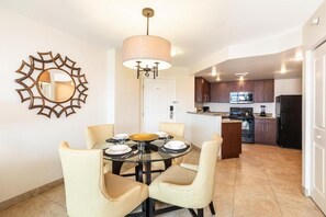 A dining area with a round table, chairs, and a hanging light fixture. - Resort in Las Vegas. Pools, spas, Gym, National Finals Rodeo week - Adjoining AB (Las Vegas)