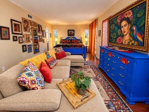 A living room with a sofa set, a blue dresser, and a painting on the wall. - Viva La Vida- Tropical Hacienda + Private Pool (El Paso)