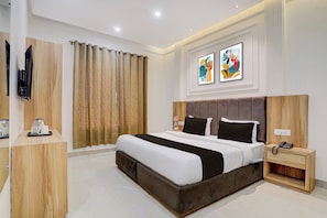 Une chambre d’hôtel moderne avec un grand lit, une table de chevet avec un téléphone et un téléviseur fixé au mur.