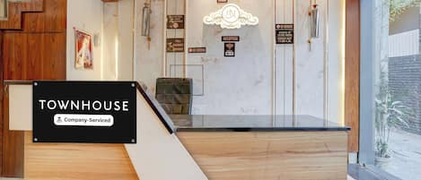 A reception desk with a sign indicating 'TOWNHOUSE Company-Serviced'.