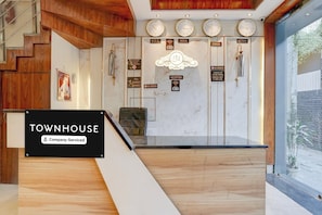 Un comptoir d’accueil avec une pancarte indiquant « TOWNHOUSE, services d’entreprise ».