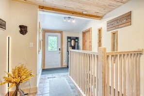 A hallway with a wooden railing, a door, and a sign that reads 'the tree house EST. 2021'. -  Large, Treehouse cottage, sleeps 15, 10 min from Ski-Wentworth, Dog Friendly (Westchester Station)