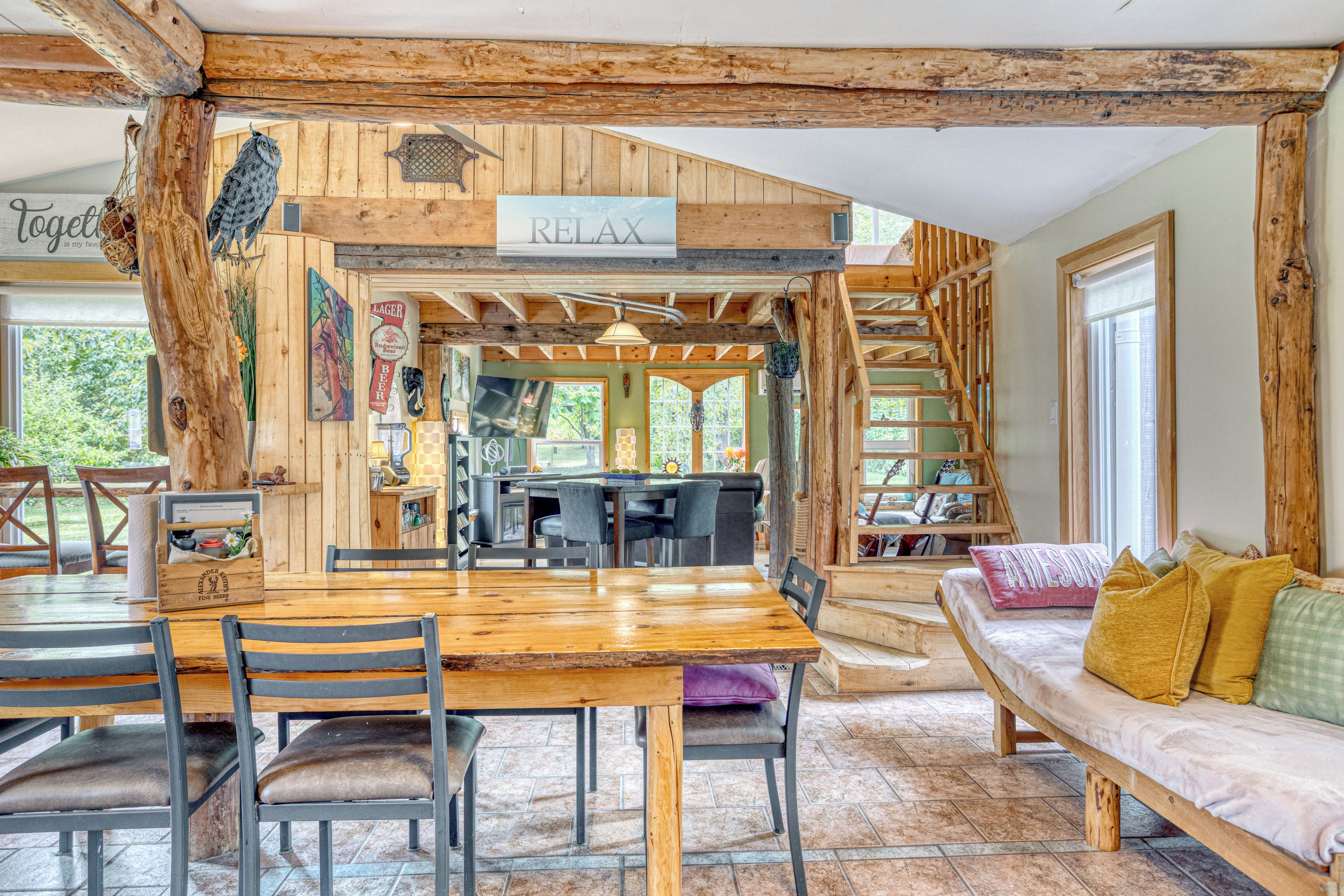 Un intérieur rustique en bois, comprenant un coin repas, un canapé et un escalier.
