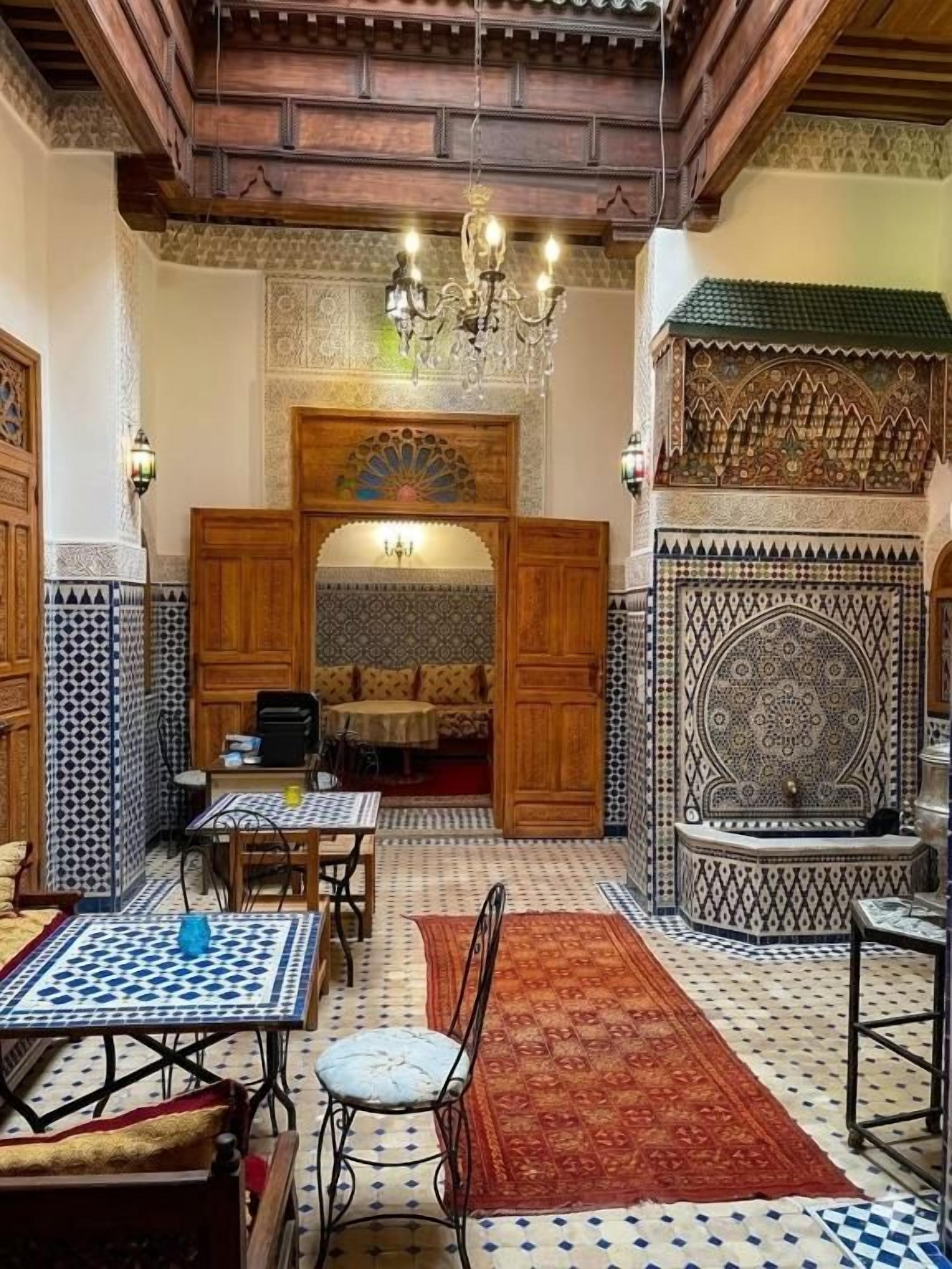 Un interior con comedor, pared con diseño y techo decorativo.