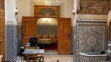 Un interior con comedor, pared con diseño y techo decorativo.
