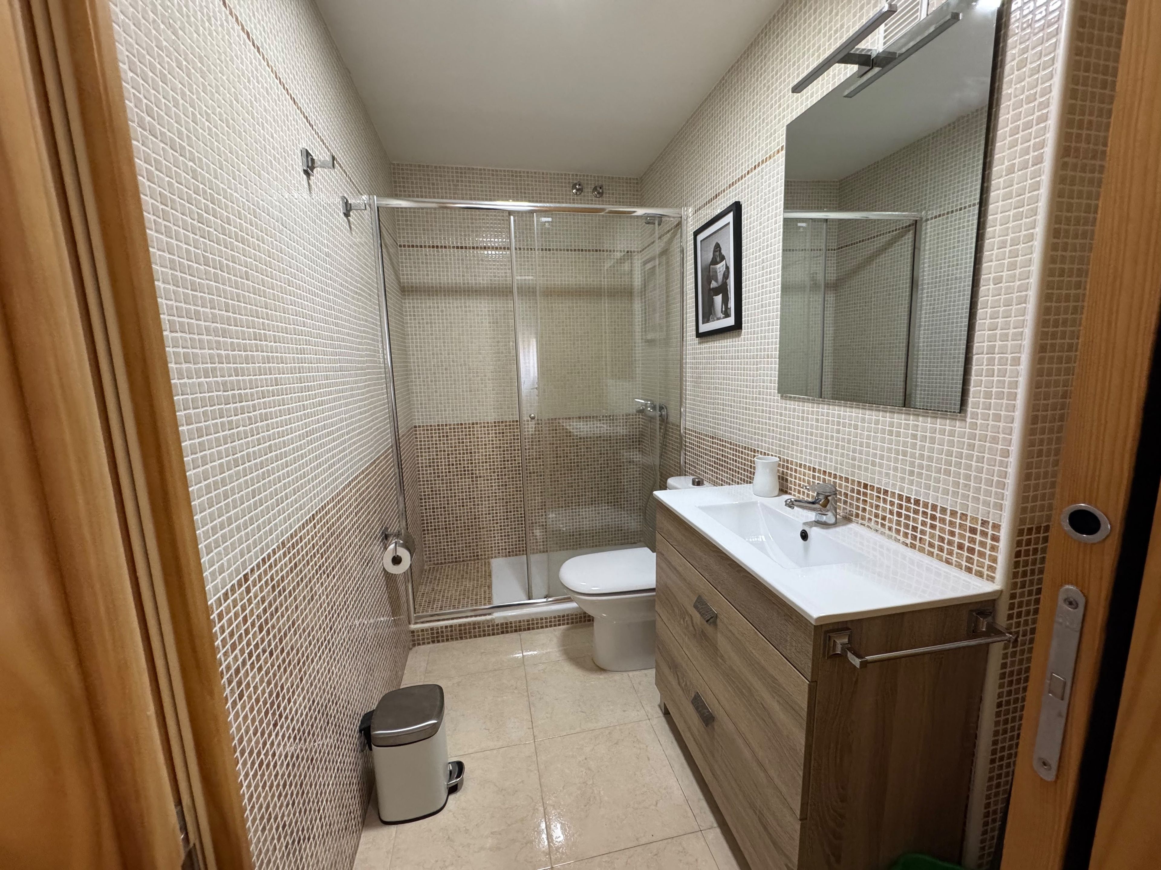 A bathroom with a shower, toilet, and sink.
