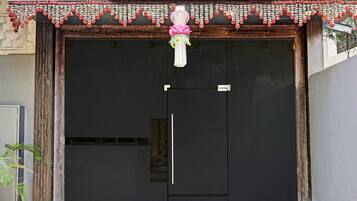 A closed shop with a decorative floral garland and a lotus flower decoration.