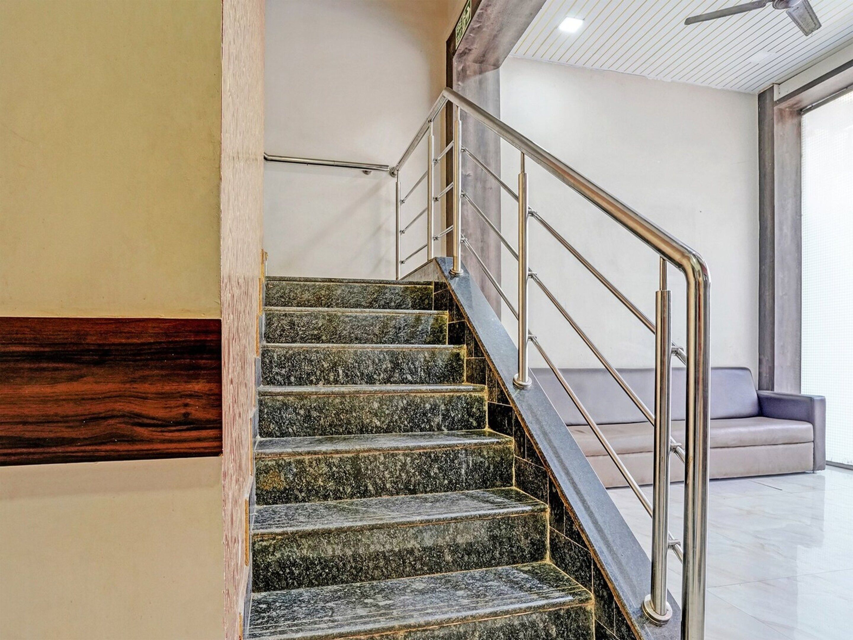 A staircase with a metal handrail and marble steps.