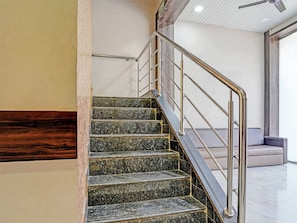 A staircase with a metal handrail and marble steps. - Classic Hotel Blue Sapphire (Mumbai)
