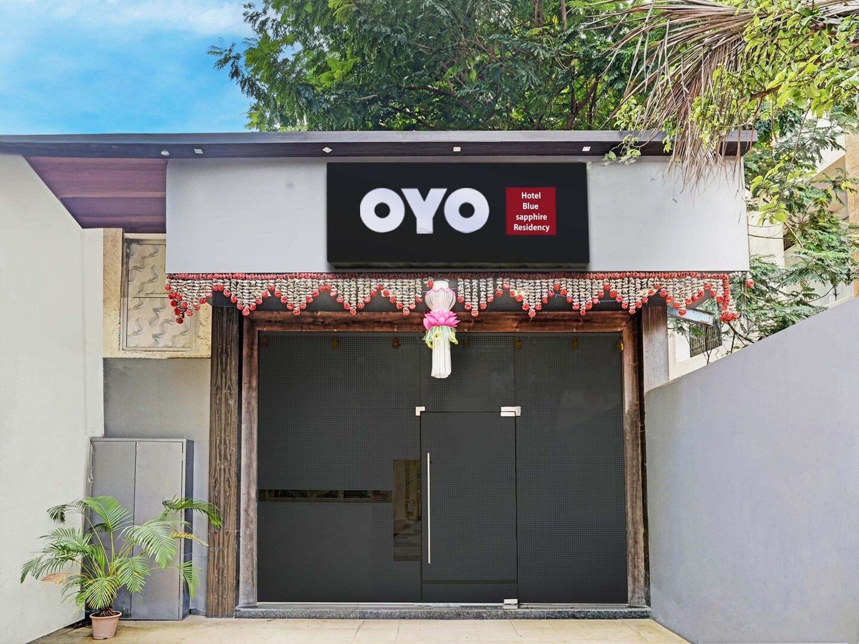A hotel entrance with a large sign reading 'OYO Hotel Blue sapphire Residency'.