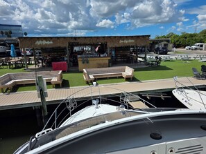 A marina with boats docked, a bar area, and outdoor seating.