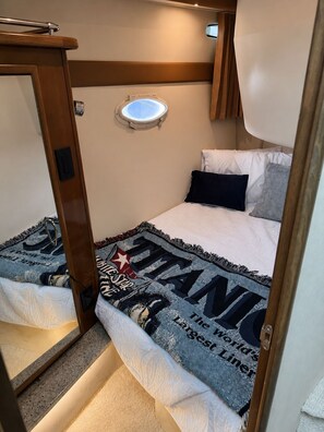 Ein kleines Schlafzimmer mit einem Etagenbett, einem kleinen Fenster und einer Tür.