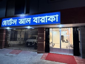 A hotel entrance with a metal gate and a red carpet leading to the door. - Hotel Al Barakah (Sylhet)
