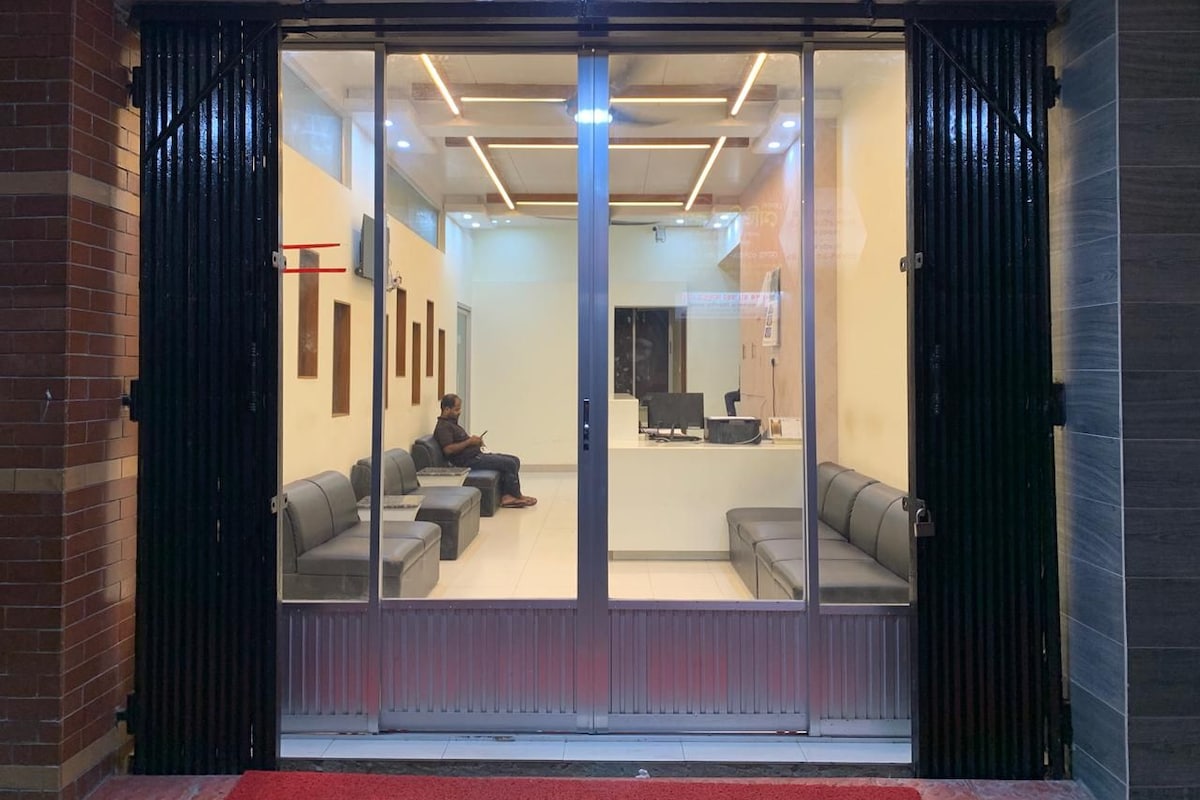 A modern interior with a reception desk, seating area, and a glass door entrance.