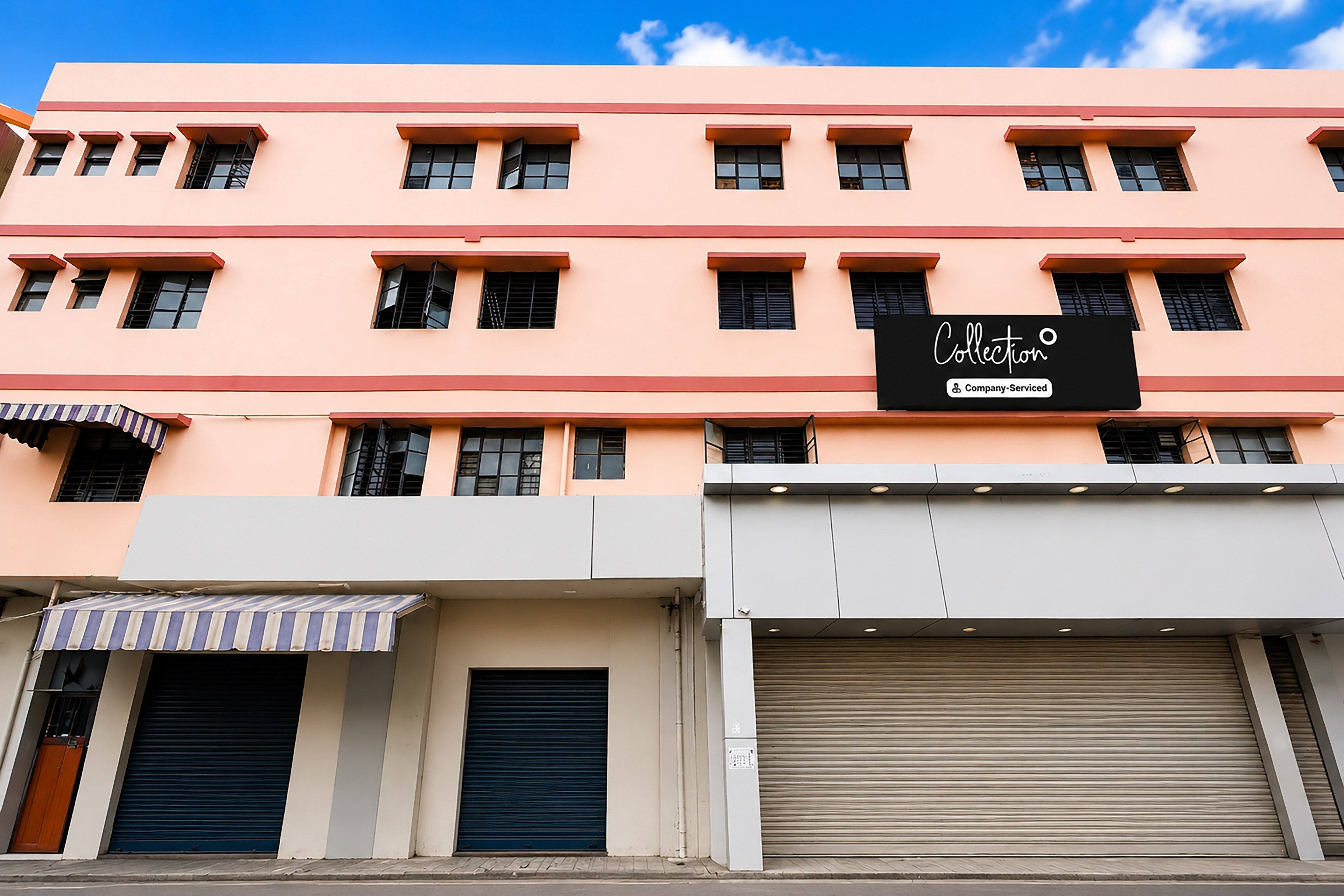A multi-story building with a flat facade, several windows, and a storefront with a sign that reads 'Collection & Company Serviced'.
