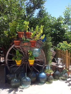 A decorative water wheel with potted plants and glass bottles.