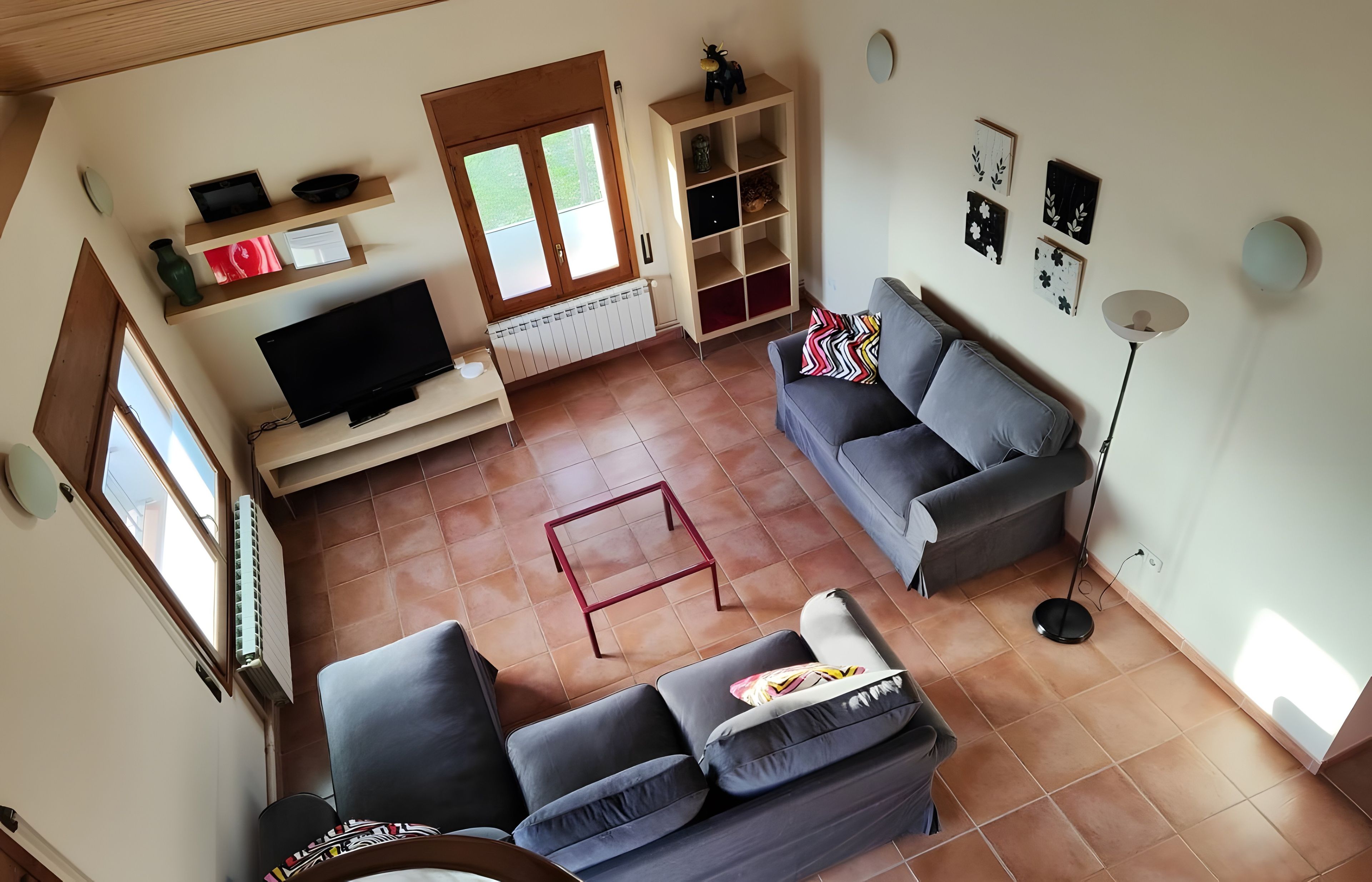A living room with a television, sofa, and a small table.