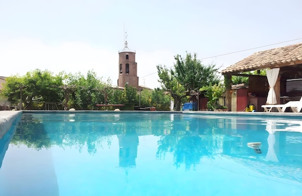 A swimming pool with a clock tower in the background.