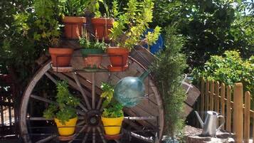 Una noria decorativa con macetas y botellas de vidrio.