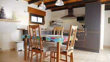 Eine Küche mit Esstisch, Stühlen und einem Kühlschrank.