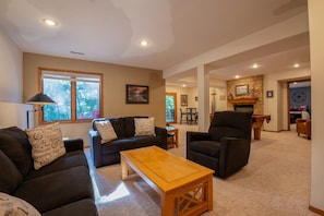A living room with a sofa, armchairs, a wooden coffee table, and a fireplace. - Spacious Family Getaway with Amenities + Pool Access (Galena)