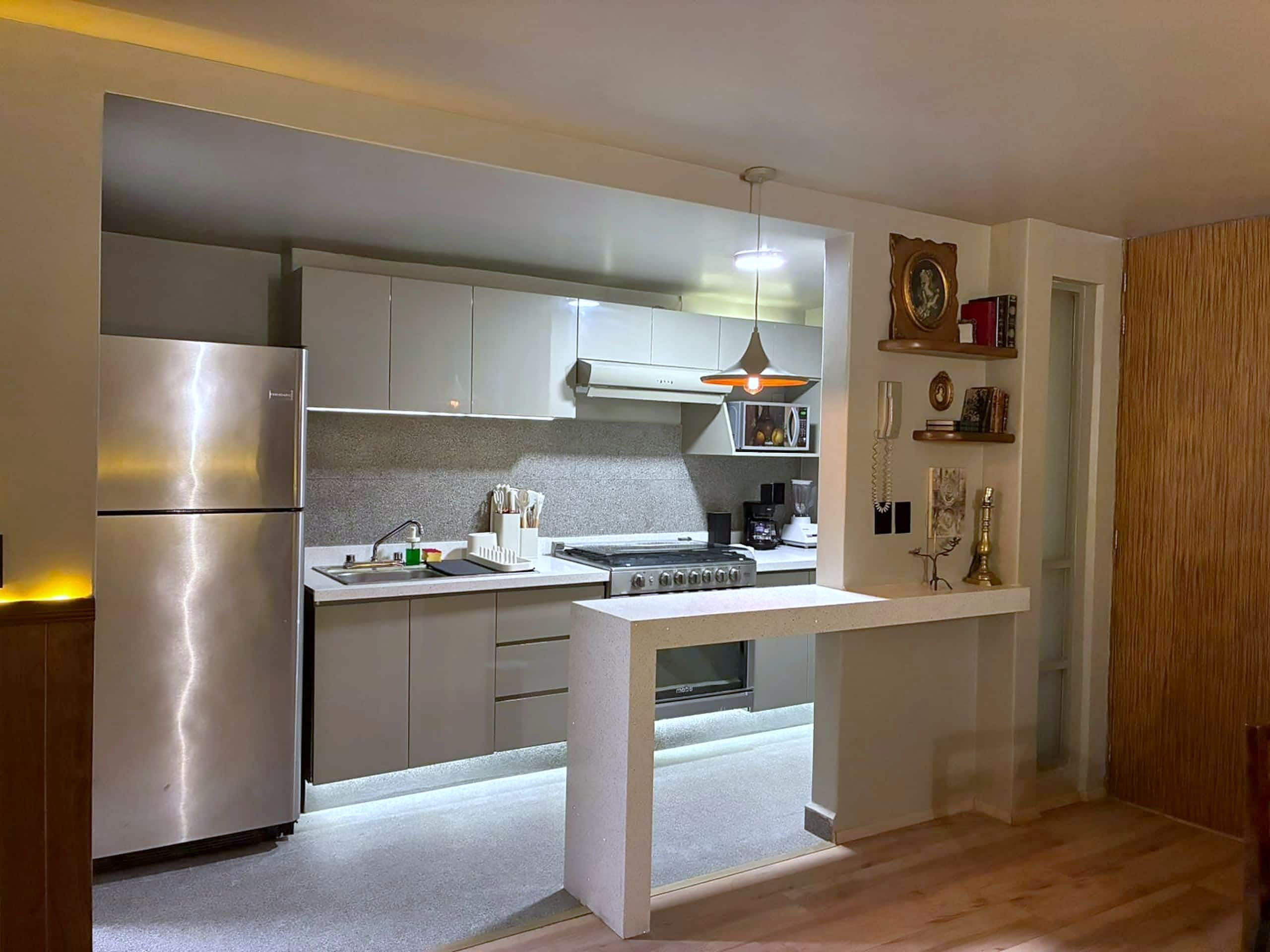Una cocina moderna con horno integrado, refrigerador y microondas.