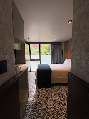 A hotel room with a bed, a desk, a television, and a view of the outdoors. - Pandora Residences  (Ciudad de México)