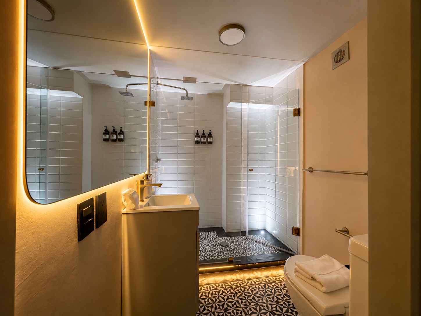 Un baño moderno con ducha, inodoro y lavamanos.