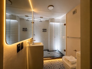 Un baño moderno con ducha, inodoro y lavamanos.