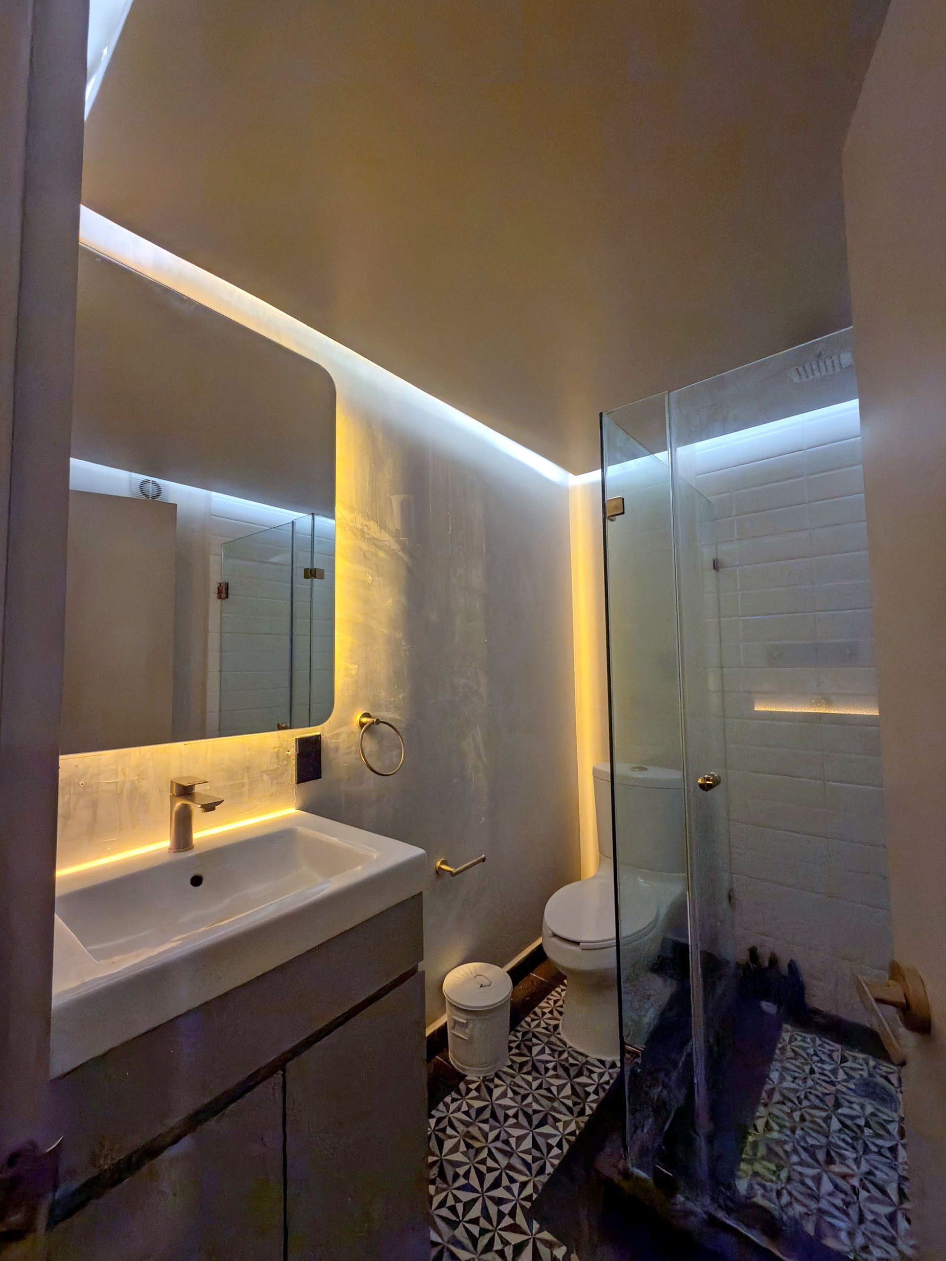 Ein modernes Badezimmer mit Duschkabine aus Glas, Waschbecken in Weiß und Toilette.