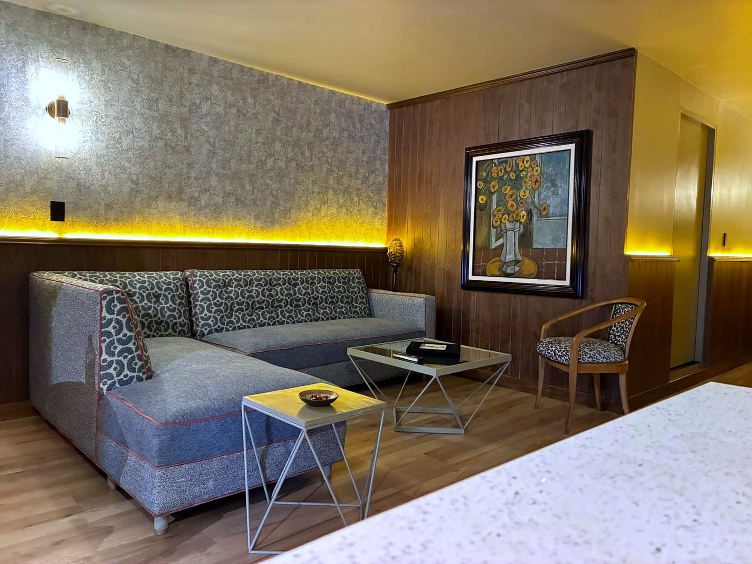 Una sala moderna con un sofá seccional, una mesa de centro y un sillón.