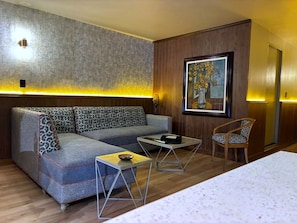 Una sala moderna con un sofá seccional, una mesa de centro y un sillón.