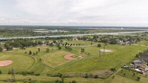Ein Baseballfeld mit mehreren Bases, ein Fluss im Hintergrund und umliegendes Grün.