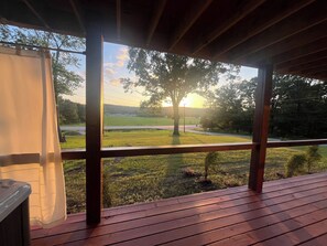 A wooden deck with a view of a grassy field and a tree. - White River Retreat Escape - Hot Tub, 5 BRs, 2 Homes (West Fork)