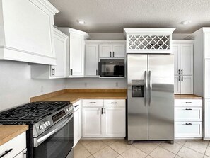 A modern kitchen with white cabinets, stainless steel appliances, and a built-in microwave. - The Ultimate Fayetteville Retreat - Two Homes, 8 BRs, 5 Mi to U of A (Fayetteville)