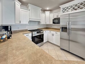 A modern kitchen with white cabinets, stainless steel appliances, and a granite countertop. - The Ultimate Fayetteville Retreat - Two Homes, 8 BRs, 5 Mi to U of A (Fayetteville)