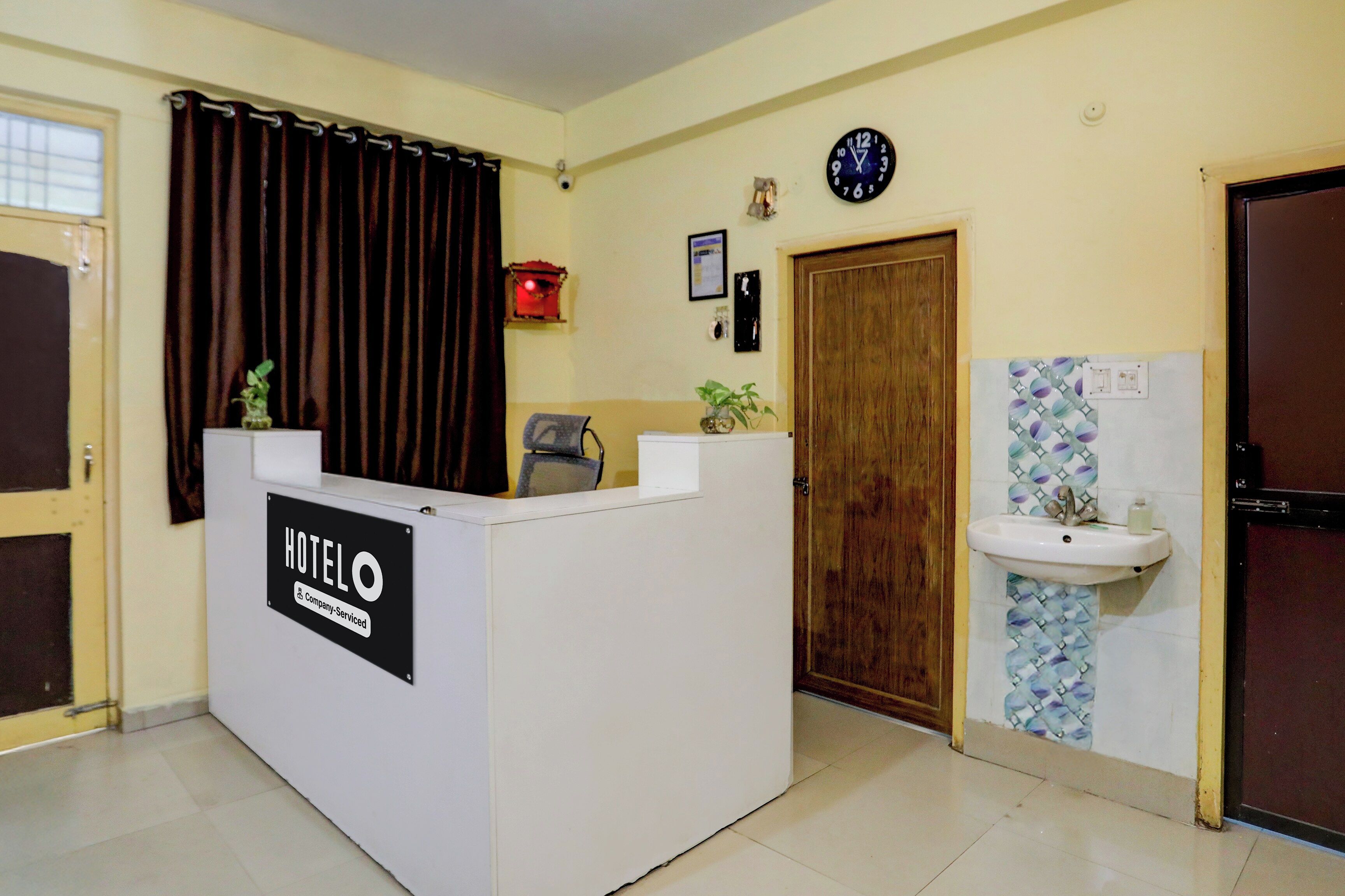 Una mesa de recepción con un letrero que dice 'HOTEL' y un reloj en la pared.