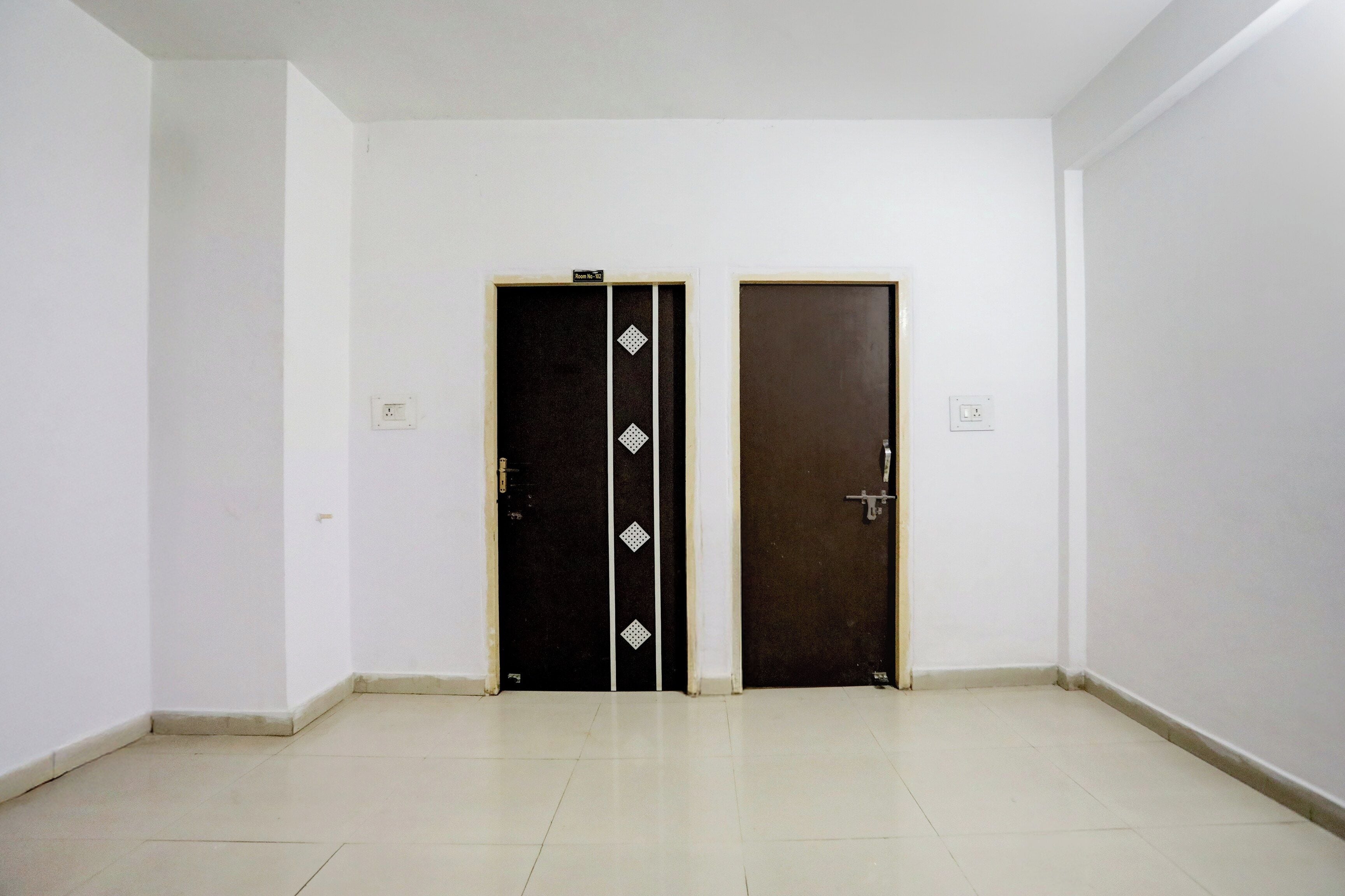Um quarto com duas portas, uma com padrão preto e branco e outra lisa.
