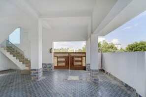 A spacious interior with a staircase, a large gate, and a tiled floor.