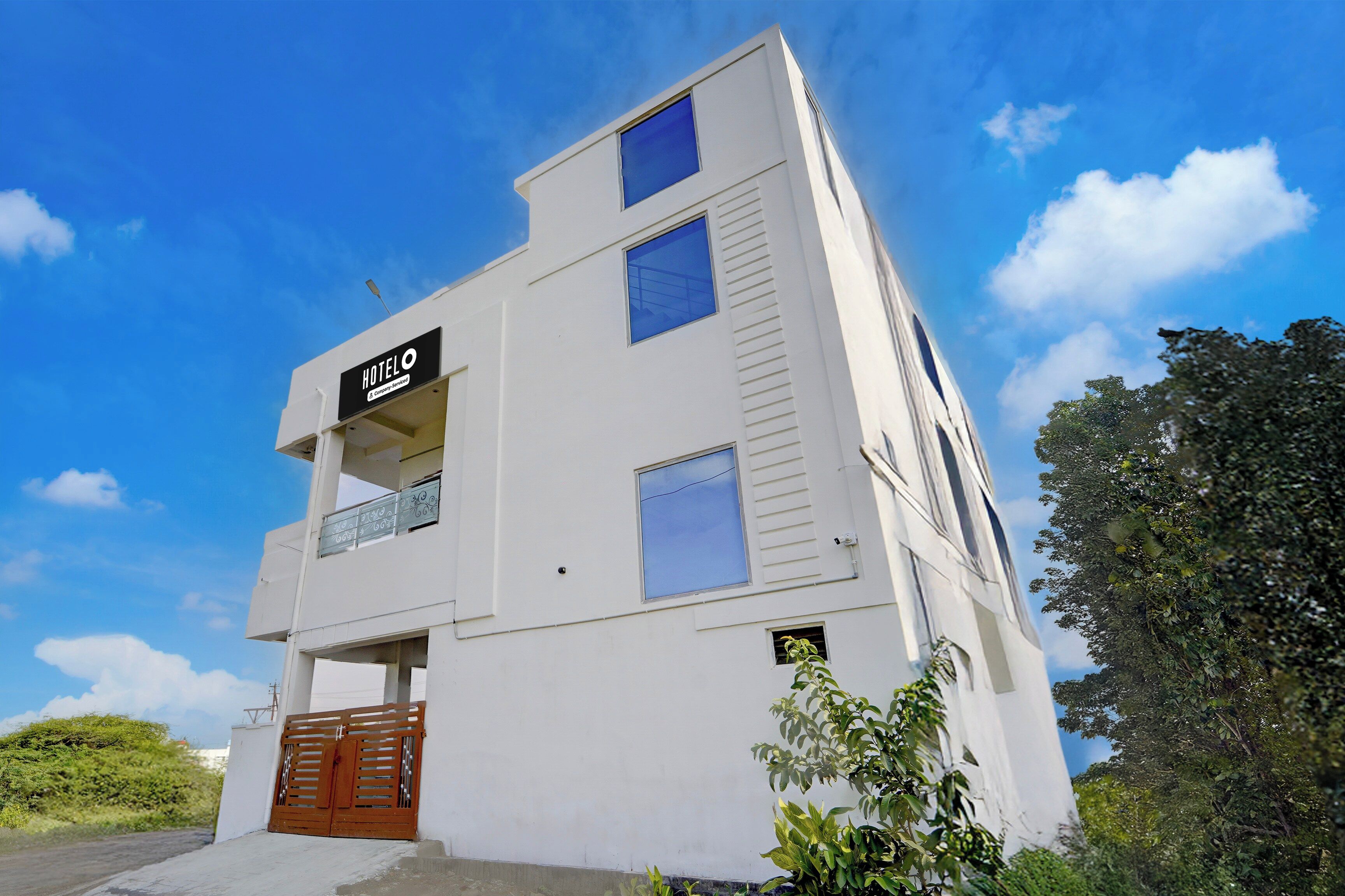 Un edificio de hotel blanco con un letrero que dice 'HOTEL & Company Services'.