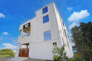 A white hotel building with a sign reading 'HOTEL & Company Services'.
