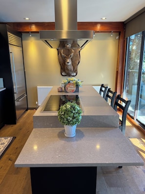 A modern kitchen with a central island, a mounted deer head, and a Thanksgiving-themed centerpiece. - Luxury Waterfront Villa Ocean Views and Private Dock North Vancouver (North Vancouver)