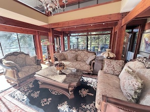 A spacious room with a large window, wooden beams, and a chandelier. - Luxury Waterfront Villa Ocean Views and Private Dock North Vancouver (North Vancouver)
