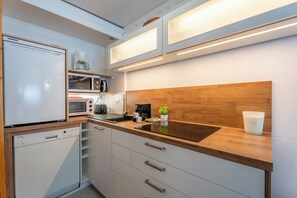 Eine kleine Küche mit Geschirrspüler, Mikrowelle und Kaffeemaschine.