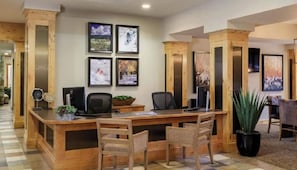 A reception desk with a computer, chairs, and framed pictures on the wall. - Sheraton Mountain Vista - 1 Bedroom (Avon)