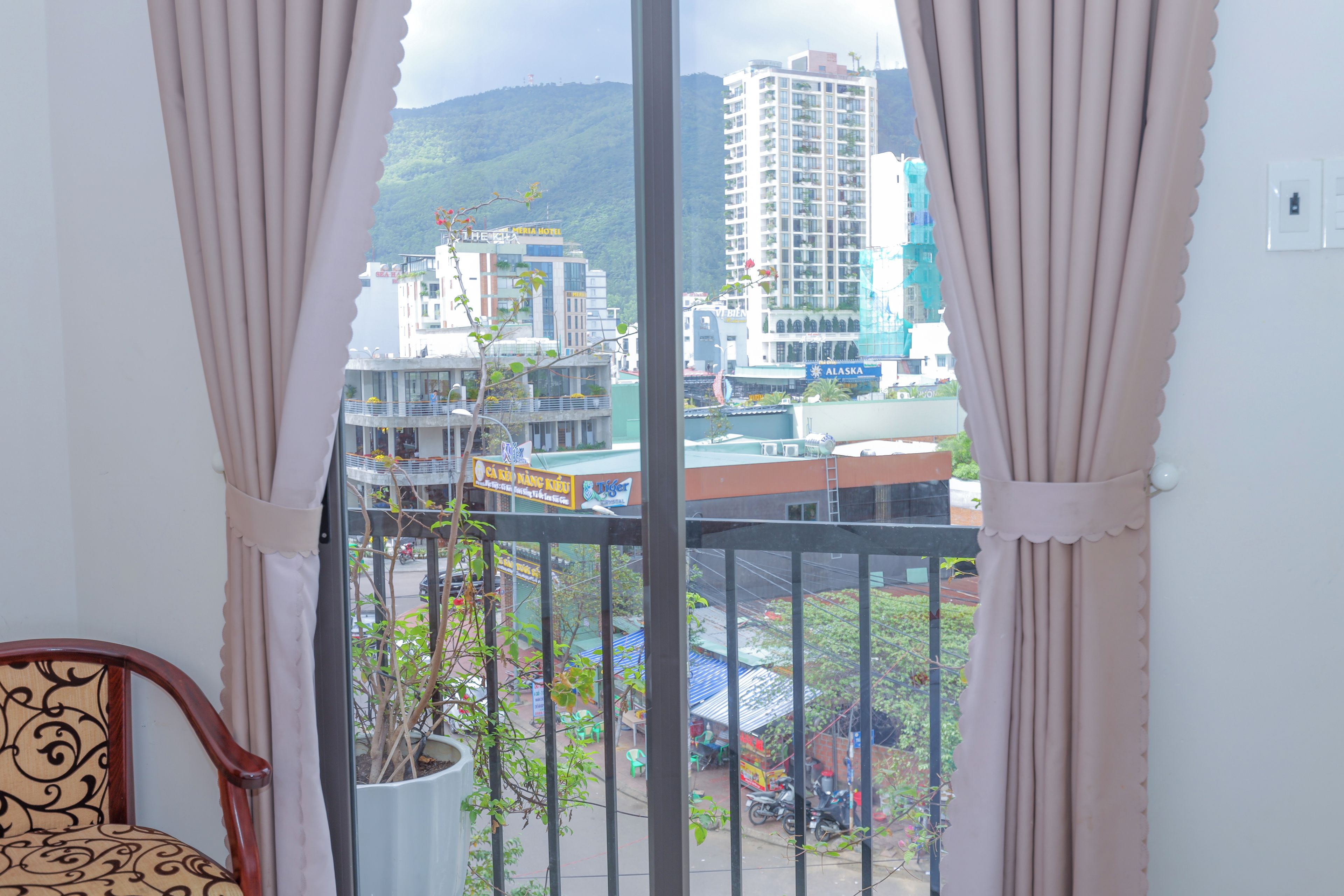 A balcony with a view of a cityscape, including buildings and a hill.