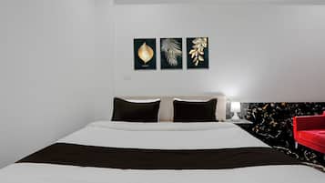 Una habitación de hotel con una cama, una silla roja y decoración en la pared.