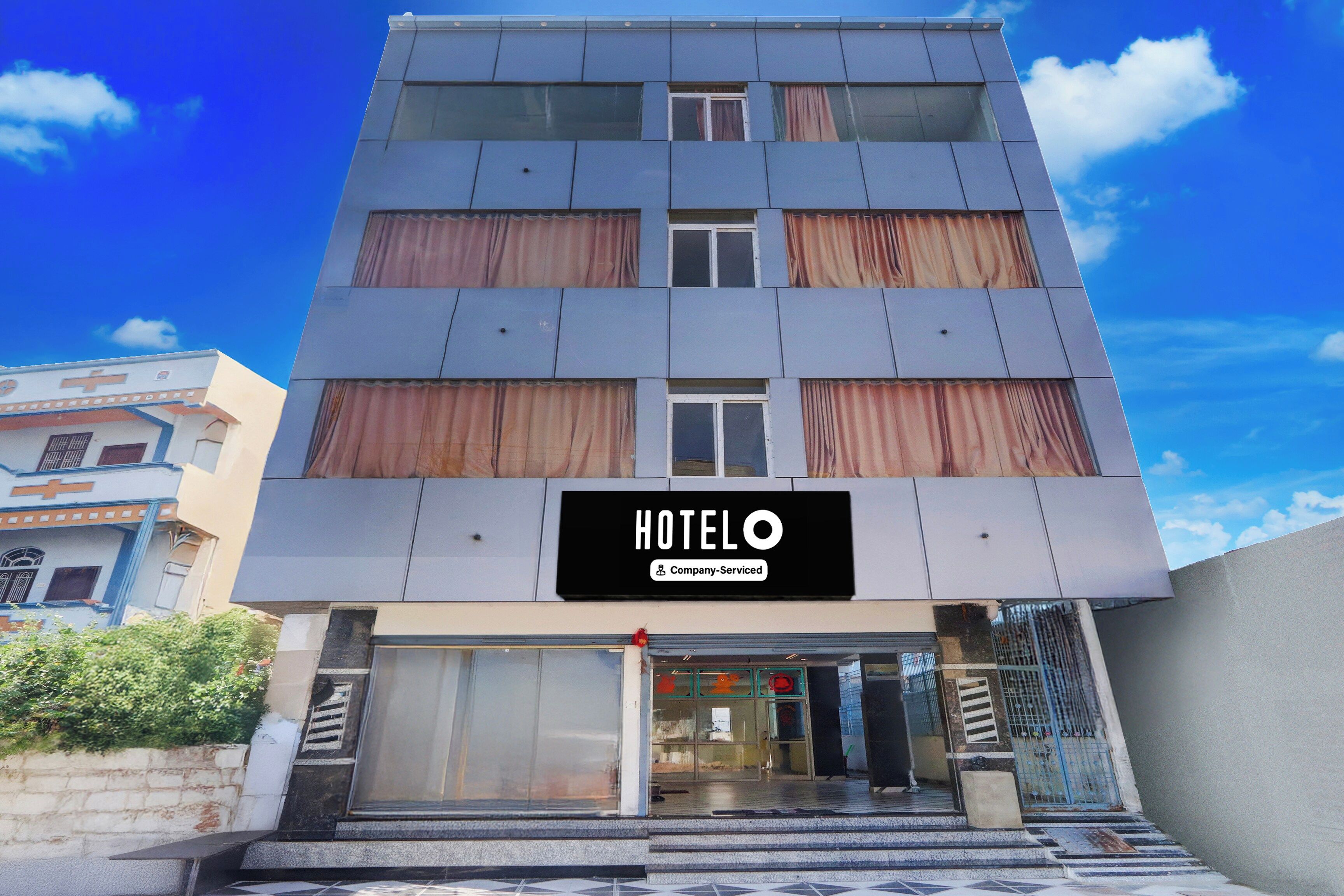 A multi-story hotel with a sign indicating it is company-serviced.