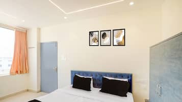 Een slaapkamer met een bed, een kledingkast en een raam met gordijnen.