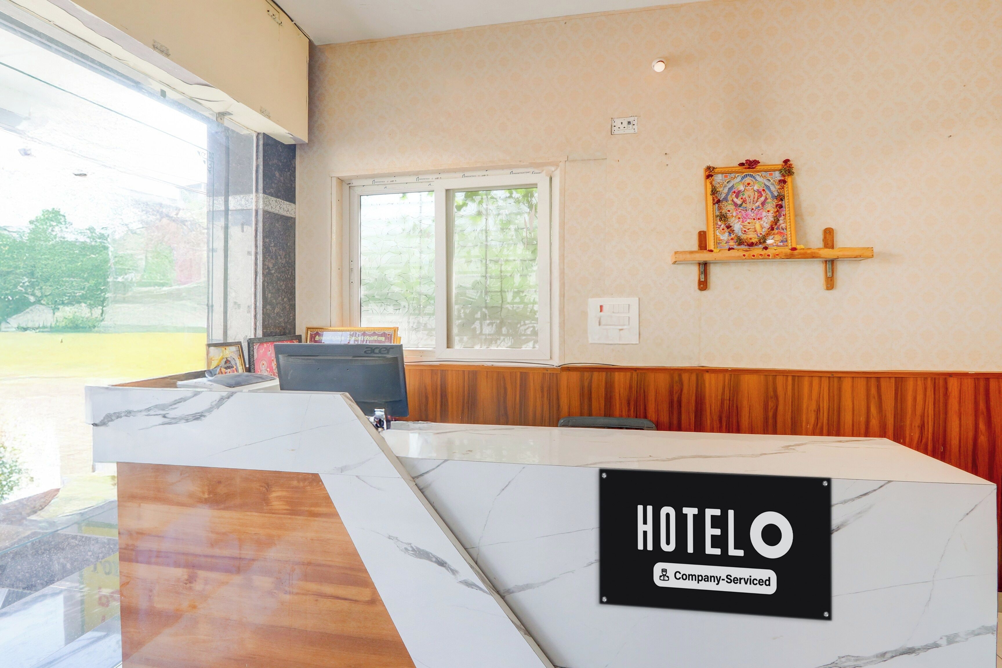 A reception desk with a marble top and a sign reading 'HOTELO Company Serviced'.